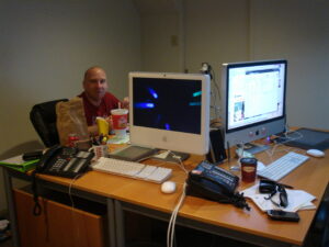 Brent eating at a desk with computers
