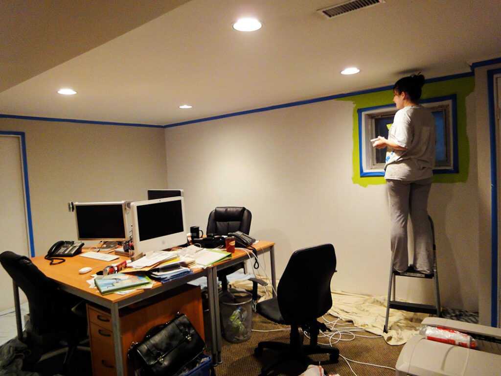 Sarah painting Fusion green on the wall in the new basement office