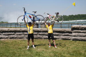 Brent and Ray holding up their bicycles in celebration.