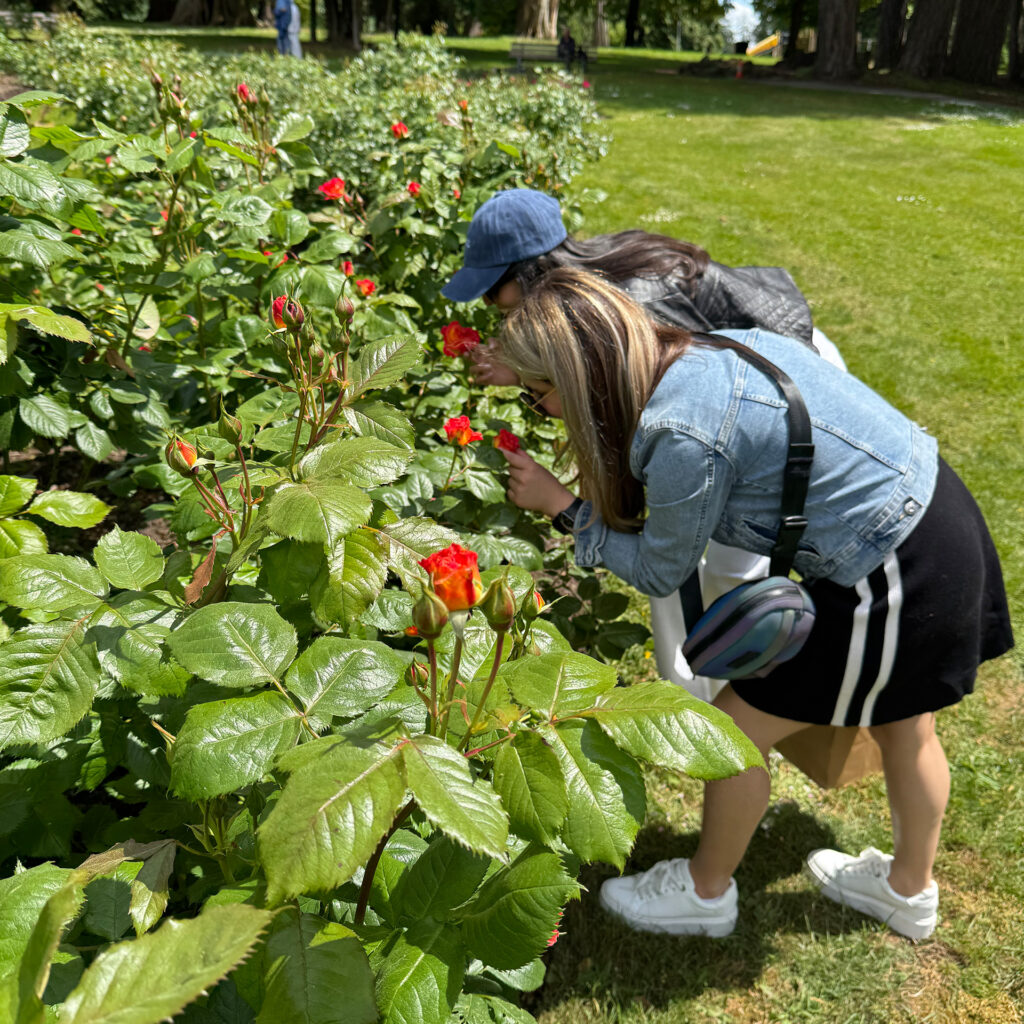 Elmira and Inji smelling the roses in the rose garden
